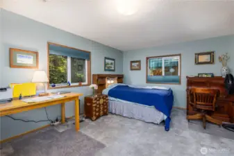 The primary bedroom offers a cozy, functional space with serene woodland views right outside the window