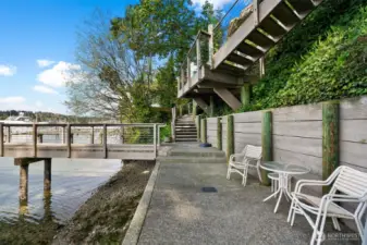 A large bulkhead runs alongside an expansive concrete walkway, offering the perfect spot to sit and enjoy the harbor from the shoreline.