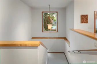 Spacious stairway to Lower level of home featuring side lights.