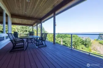 Spacious upper deck with plenty of room for entertaining and taking in the views. Notice the transparent panels in the railing system for optimal viewing. The deck wraps around the north side of the house and is accessible from the left side of the main entrance .