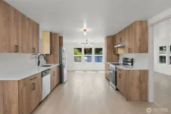 Another view of kitchen and dining area with living area and front door to the right
