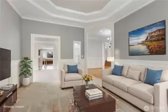 The formal living room features wainscoting, coved ceiling, new carpet, built-in display case with lighting and easy access to the dining room.