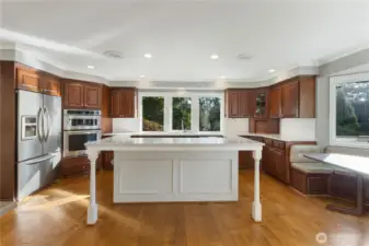 Additional view of the kitchen.  The kitchen features a bar at the island plus a built-in eating area and access to a large deck.
