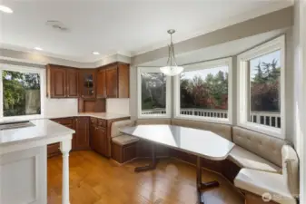Windows wrap around the built-in dining area and provide beautiful views of the property.