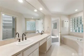 The primary bath features a large soaking tub, double sinks, tile work, walk-in shower with dual shower heads and bidet.