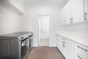 Open laundry room with plenty of storage make handling laundry a cinch!