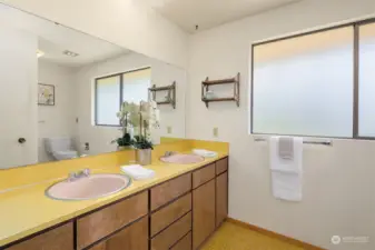 The spacious hall bath has two sinks, lots of storage, and a tub/shower adjacent to the toilet.