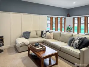 A few steps down from the dining area is an expansive living room, with walls of windows and a gas stove/fireplace.