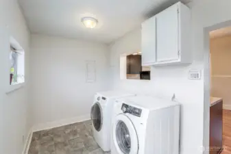 Large laundry room with newer washer and dryer