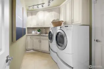 Dedicated laundry room with storage cabinets and utility sink for everyday ease.