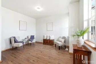 The formal living room features gorgeous new LVP flooring and fresh paint throughout. Large windows allow natural light to pour in, creating a bright and airy feel.