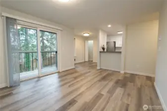 Very Large living room and balcony area.  New paint + luxury vinyl plank flooring + all new kitchen cabinetry and quartz countertops.