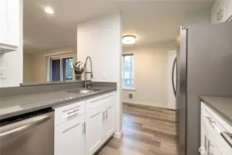 Kitchen features brand new cabinetry + stainless steel appliance suite (fridge, range, dishwasher and microwave). New quartz countertops.