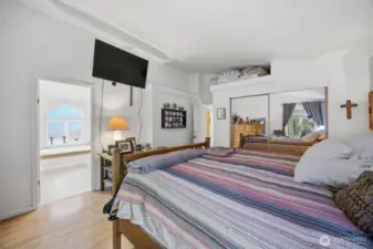 Looking across the primary suite toward the spa like bath with a separate tub and shower and a toilet room.