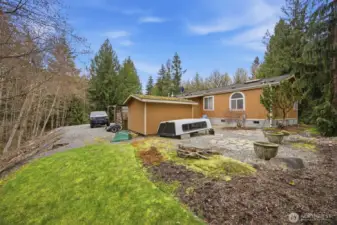 Looking at the NE corner of the home with the storage shed and firewood storage areas.