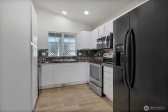 Kitchen is updated with painted cabinets, granite counters and tile backsplash.