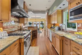 The chef’s style kitchen dazzles with seafoam granite countertops and top-of-the-line appliances including Wolf range & Subzero refrigerator.