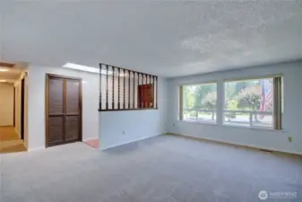 Another view of the living room with the wall of windows. Looking toward the entryway and hallway toward bedrooms.