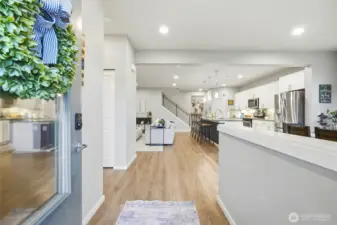 Bright and open entryway leading into a spacious open-concept floor plan with modern finishes, ideal for today’s buyers seeking functional living space.