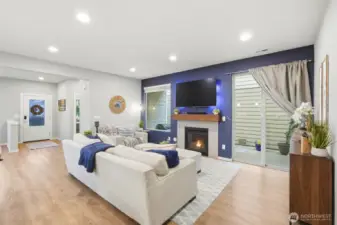 Spacious living room with gas fireplace, large windows, and modern design creating a warm and inviting gathering space.