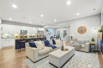 Wide-angle view of living room and kitchen highlighting open-concept design and modern finishes throughout.