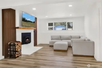 Spacious downstairs extra family room with wood burning fireplace, creating a warm and energy-efficient retreat for cozy winter evenings!