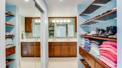 Additional closet space and built-ins lead you to the primary bathroom.