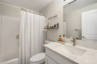 Hall bath offers newer vanity, quartz countertop, tiled tub surround, ceramic tiled flooring, toilet, and light fixture.  All updated nicely.