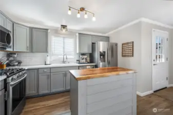 Ample size kitchen, quartz countertops, updated cabinets, with all Stainless Steel Samsung appliances (All stay) and butcher block kitchen island with extra storage.