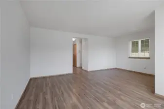 A full view of the Living Room from the Front Window. The front door is on the Right. Down the hall is the main bath, Kitchen & Dining Area.
