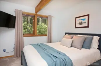 Bedroom #2 has a standard sized closet and looks out towards the forest, including the large parcel of acreage to the west of you. The TV conveys.