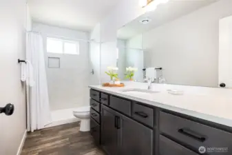 Spacious counter and tile shower in the primary bath