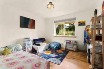 The third bedroom looks out to the forested back lot.