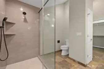 Walk-in shower with glass enclosure.