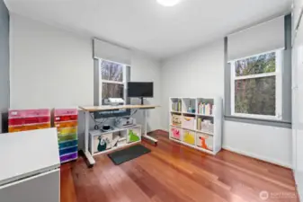 Bedroom with hardwood floors and lots of natural light coming through.