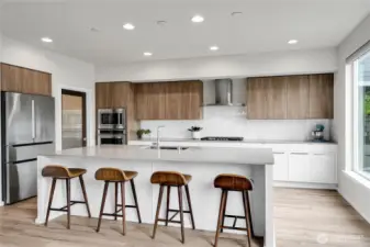 The palatial kitchen is a chef’s dream and features a gigantic quartz center island and a long breakfast bar and pull-out garbage & recycle bins tucked underneath.