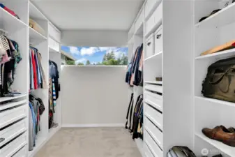 A spacious walk-in closet with lots of high-quality organizers is located off the primary bath. In this closet there are multiple drawers, shelves and clothes hanging sections.  Plus there is a long window that lets in natural light.