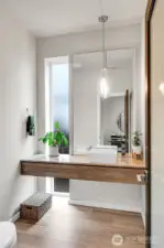 A half bath is centrally located on the main level and features a vanity counter with a contemporary raised sink basin. Quality Grohe faucets and Kohler toilets.