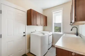 Enjoy everyday convenience in this well-appointed laundry room, featuring ample storage, counter space, and modern appliances to make laundry a breeze.