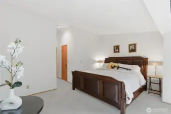 master bedroom with large windows and vaulted ceiling.