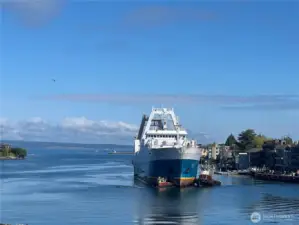 Near continual parade of North Pacific fishing fleet vessels. This one getting help from two tug boats.