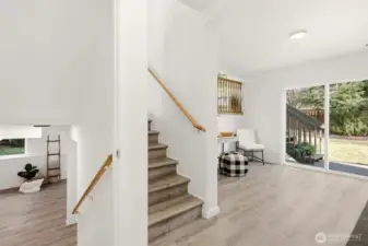 Upper stairs take you to the kitchen and dining area. The lower stairs lead to the spacious flex space offering many possibilities.