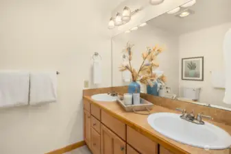 The primary en suite bathroom has double sinks, a shower, and lots of storage.
