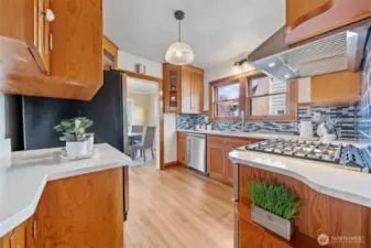 A bright and inviting kitchen features solid wood cabinetry, sleek quartz countertops, and a stylish tile backsplash that adds a pop of color and character.