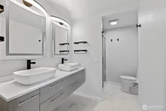 Primary bath is complete with double vanities and tile walk-in shower