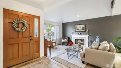 This charming living room offers comfort and character right as you walk in, with vaulted ceilings and a wall of windows bathing this space in natural light.