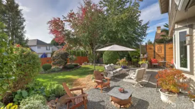 Outdoor living at its best with a fire pit, lounge areas, and lush greenery.