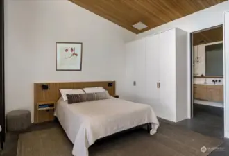 Primary Bedroom featuring a custom-designed solid white oak headboard with integrated nightstands, power outlets, and lighting.