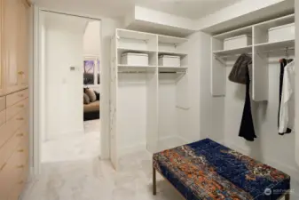 Generous walk-in closet with custom built cabinetry.