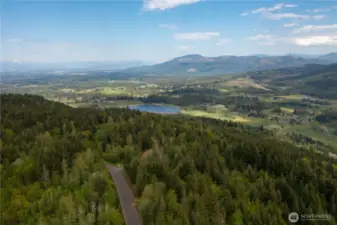 Aerial View looking at Squalicum Lake, Valley, with the Canadian Coastal Mountain range in the distance